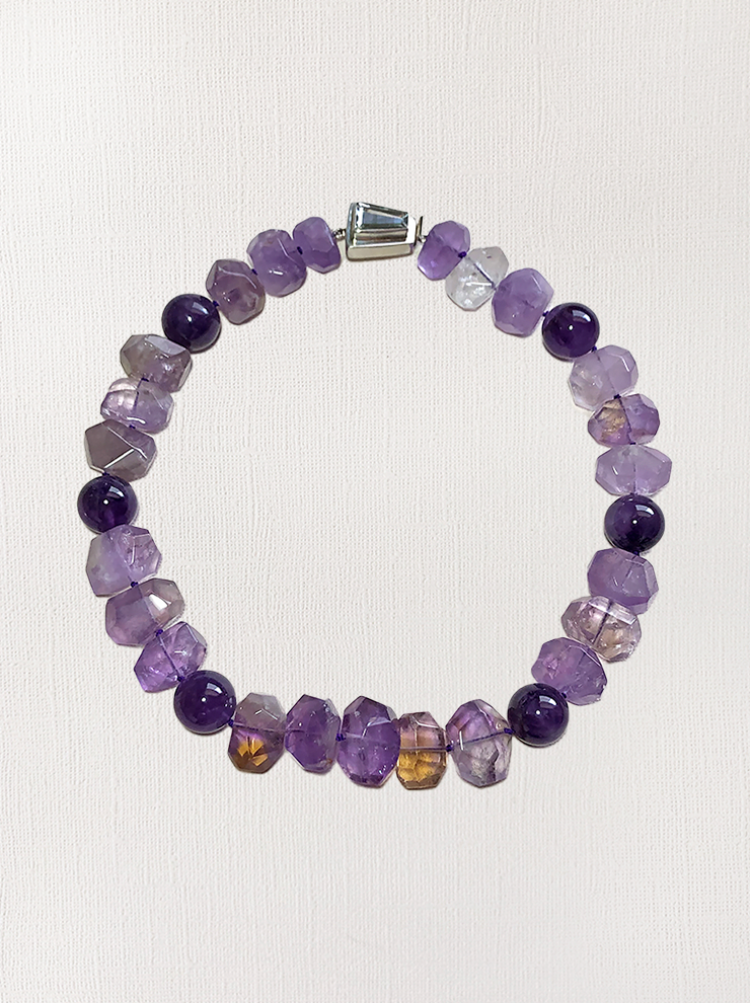 A women's beaded necklace made with amethyst and citrine nuggets, along with round amethyst beads.