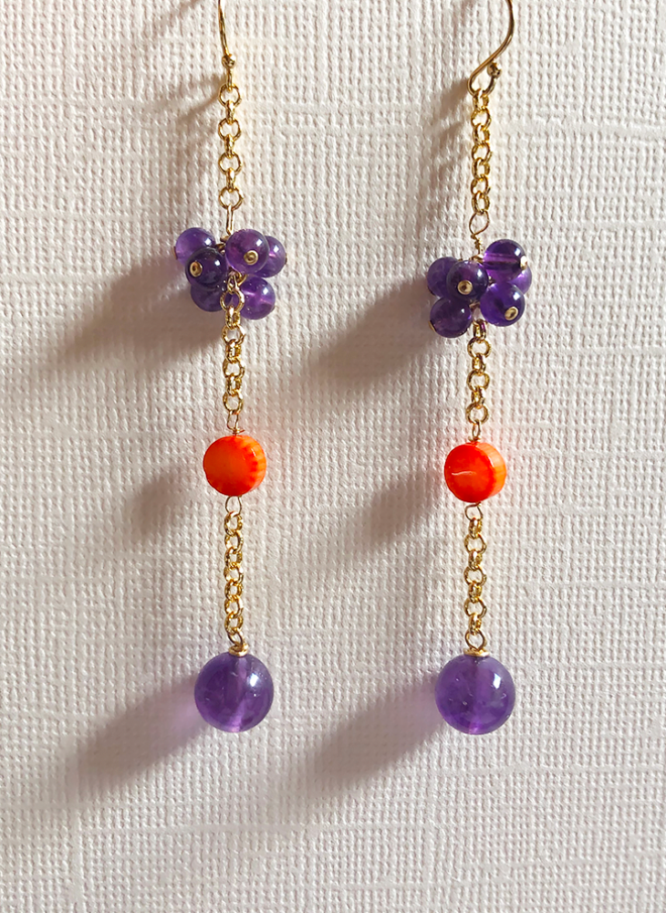 Gold chain drop earrings featuring amethyst and orange sea bamboo coral.